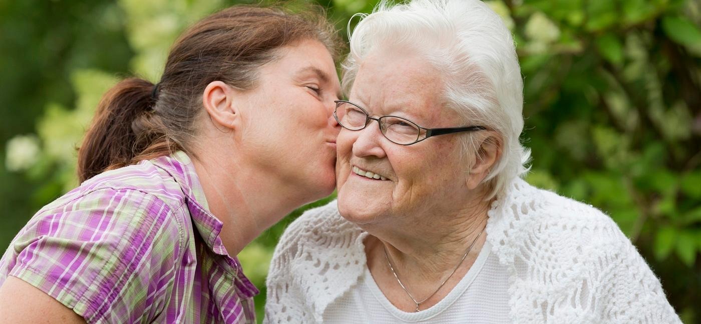 Barnbarn pussar sin mormor på kinden